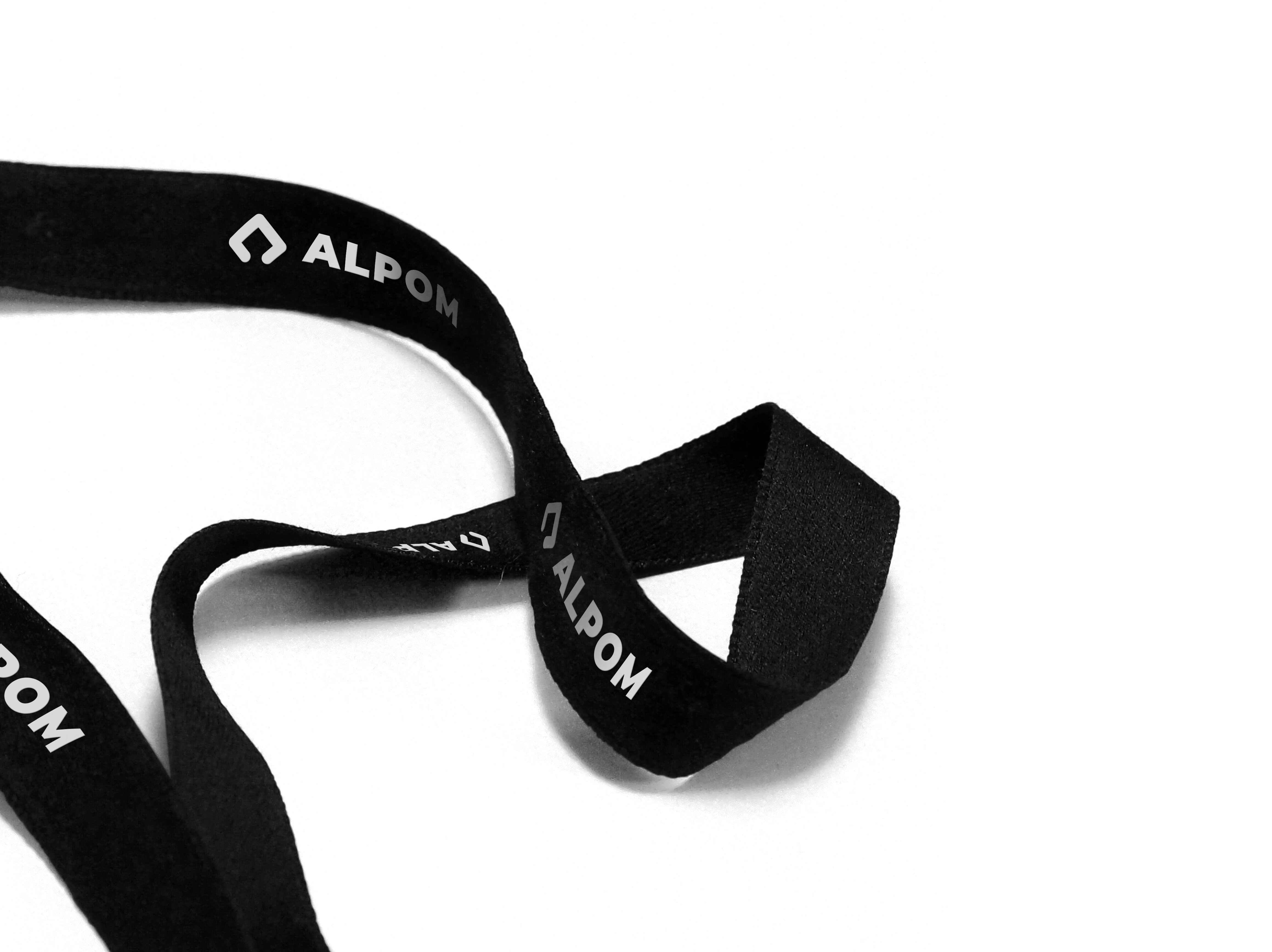 Black lanyard with Alpom's horizontal logo lockup in white.